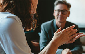 A man and woman sitting together at a table, exploring methods for finding a job in the USA, with relevant text displayed.