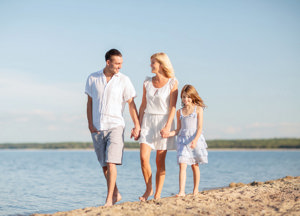 Eine glückliche Familie spaziert am Strand und genießt die Sonne und das Meer.