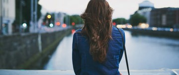 eine einsame Frau mit Blick auf die Straße, die die bevorstehende schwierige Reise symbolisiert