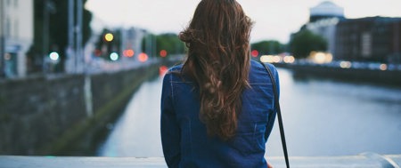 eine einsame Frau mit Blick auf die Straße, die die bevorstehende schwierige Reise symbolisiert
