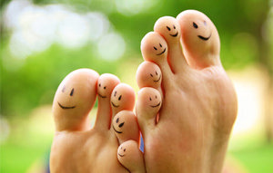 Füße einer Person, die mit bunten Smileys bemalt sind, strahlen Freude und Kreativität aus.