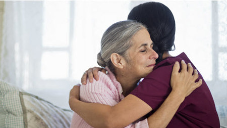 Nurse hugging female patient