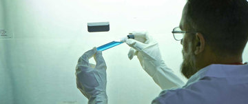 Scientist holding a blue vial
