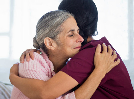 A nurse hugging a patient
